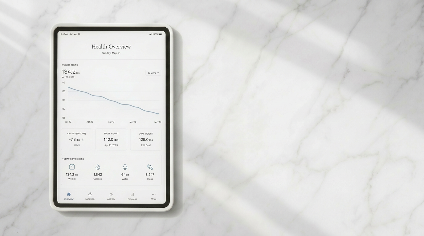 Overhead flat-lay of a white marble worktop with an iPad displaying a minimalist health dashboard